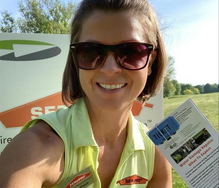 female employee with glasses on holding up marketing material